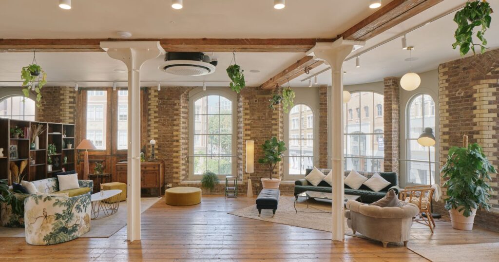 Heritage office lounge at Menier Venues with exposed brick walls, arched windows, wooden floors and modern furniture