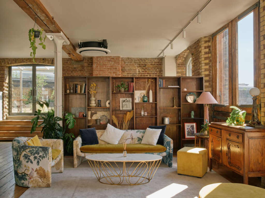 Stylish lounge area with vintage furniture, bookshelf, and decorative accents in a loft-style interior