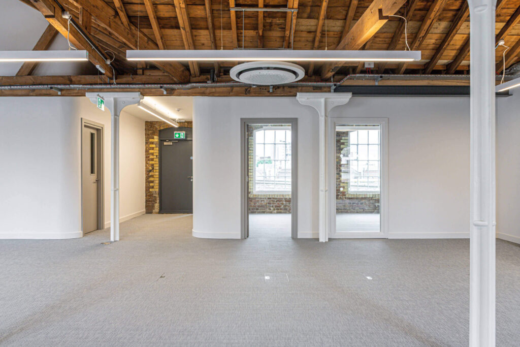 Exposed timber roof in open-plan office with windows